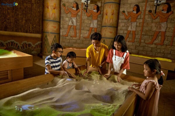 Trẻ em hào hứng tương tác với mô hình cát điện tử 3D tại khu vui chơi trong nhà mát mẻ, dịch vụ đã nằm trong giá vé VinWonders Phú Quốc trọn gói