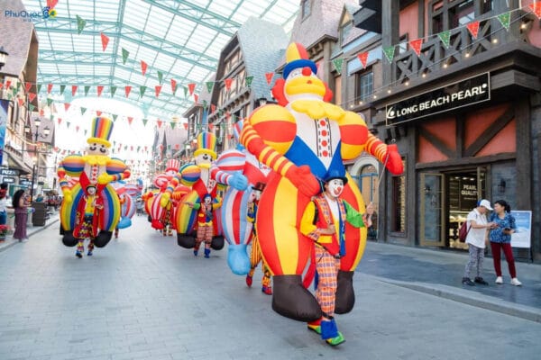 Đoàn diễu hành vũ hội Carnival náo nhiệt với các chú hề bong bóng khổng lồ đa sắc màu trên trục đường Đại lộ Châu Âu cổ kính.