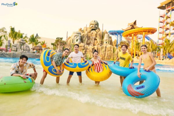 Nhóm bạn trẻ vui chơi thả ga với phao bơi tại bể tạo sóng công viên nước trong VinWonders Phú Quốc