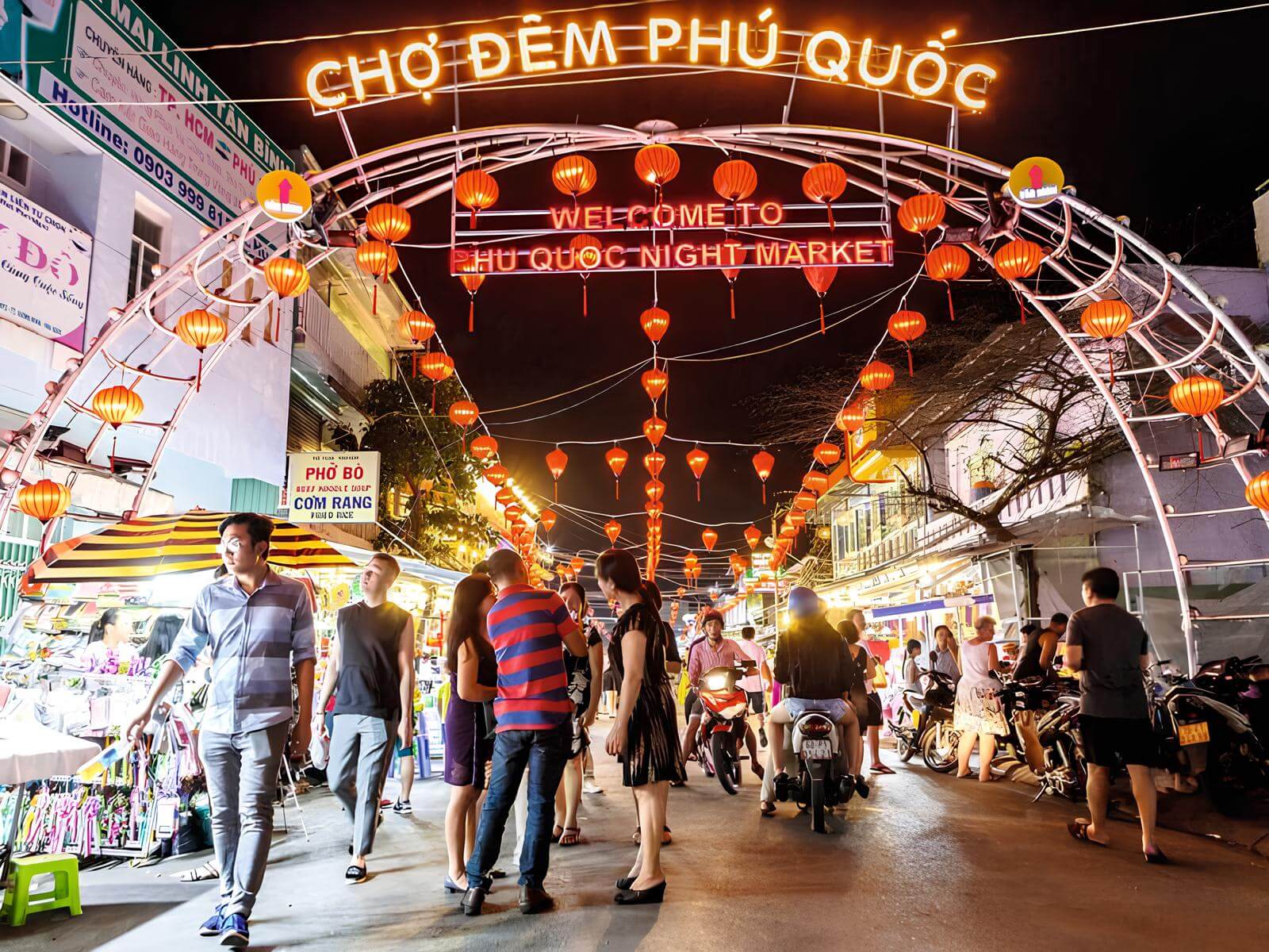 Khung cảnh cổng Chợ Đêm Phú Quốc sầm uất với nhiều du khách và quầy hàng ẩm thực đường phố hấp dẫn