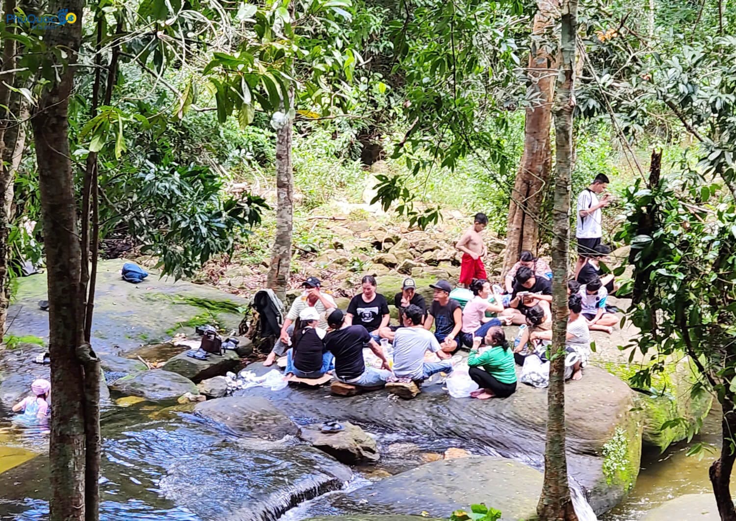 Gia đình đang cắm trại picnic và dùng đồ ăn an toàn trên phiến đá lớn bên bờ Suối Tranh.