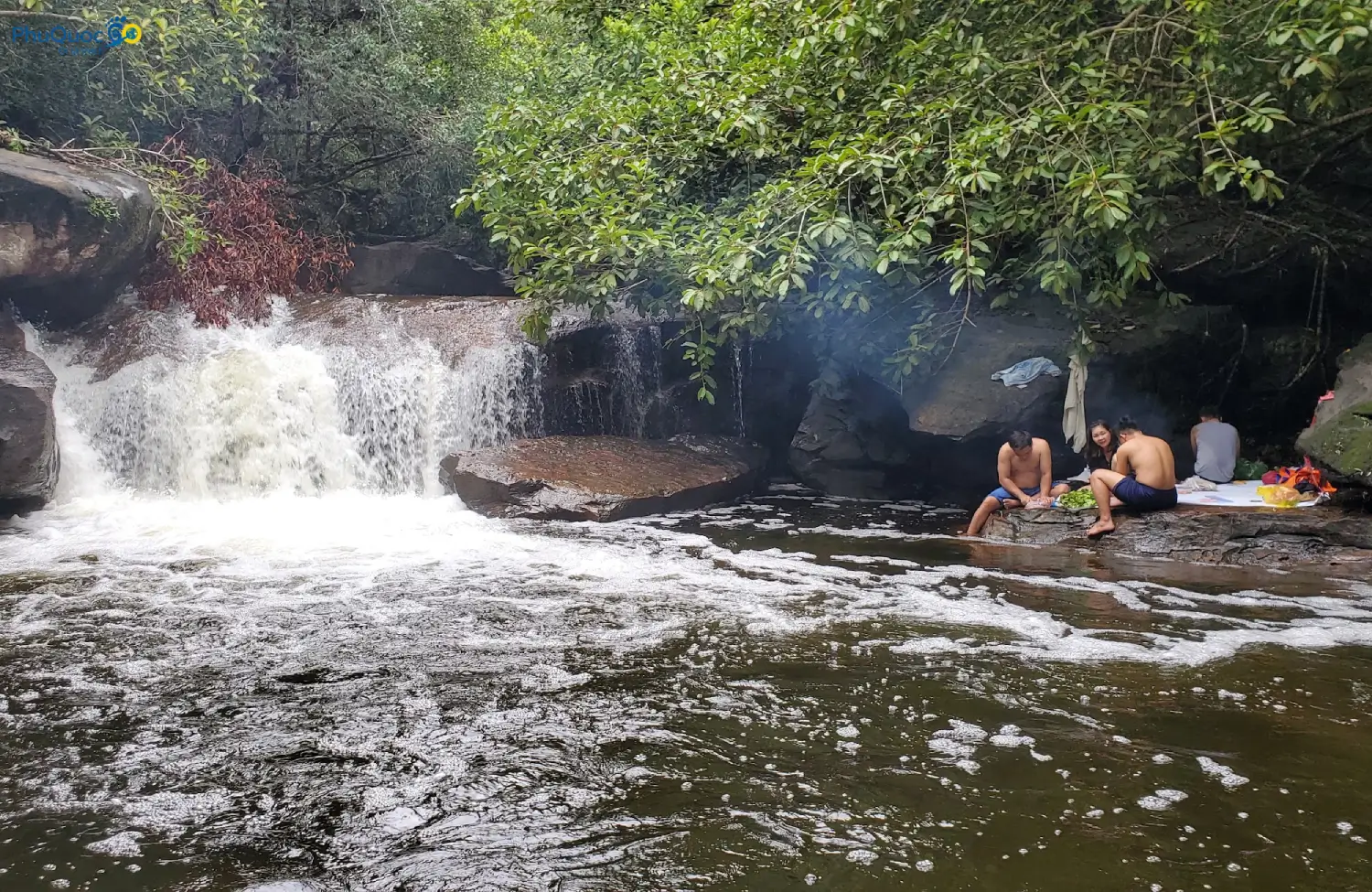 Group of friends having a picnic on flat rock at Suoi Tien Phu Quoc