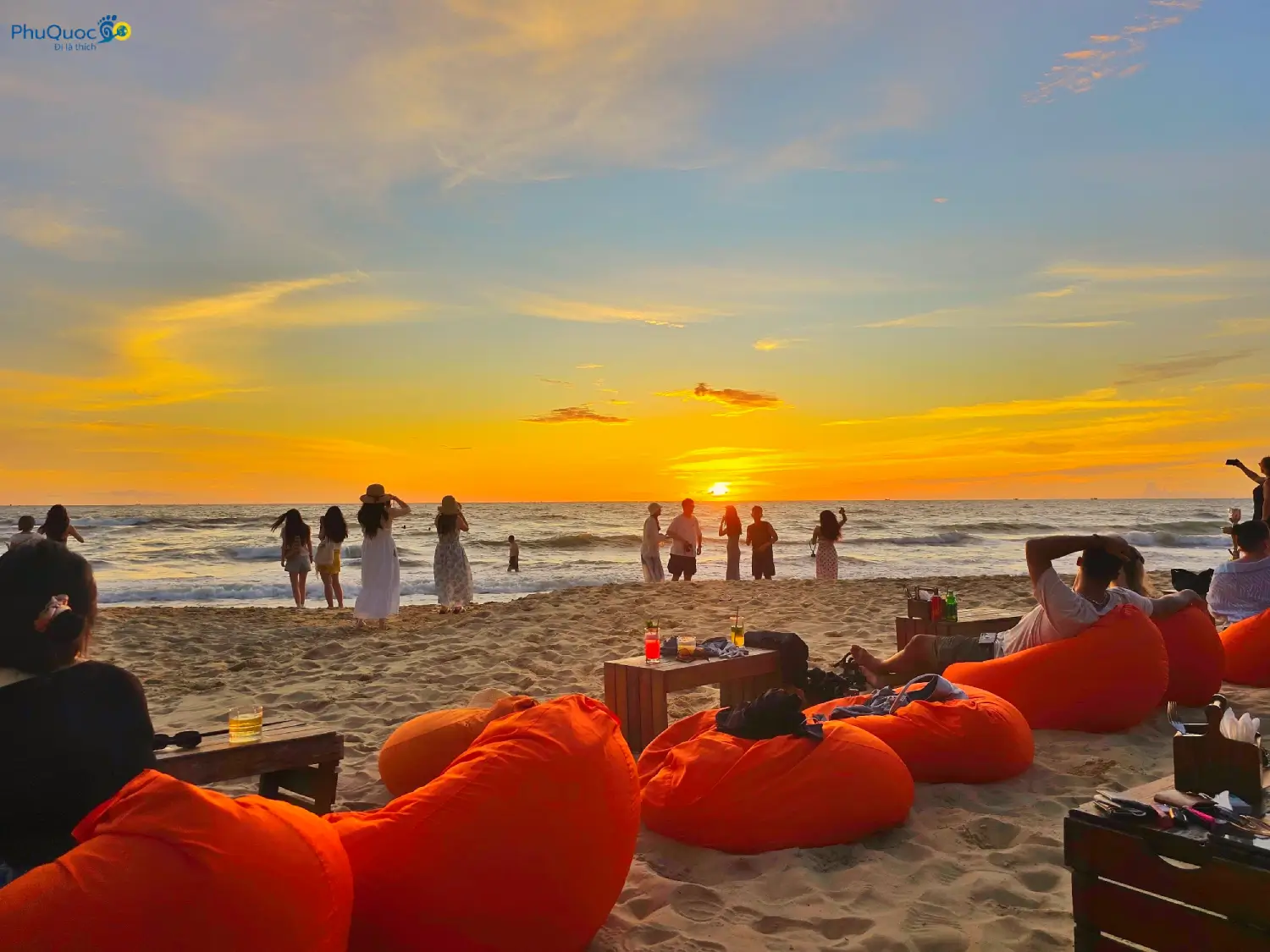 Du khách thư giãn trên ghế xốp màu cam ngắm mặt trời lặn tại OCSEN Beach Bar Bãi Trường Phú Quốc